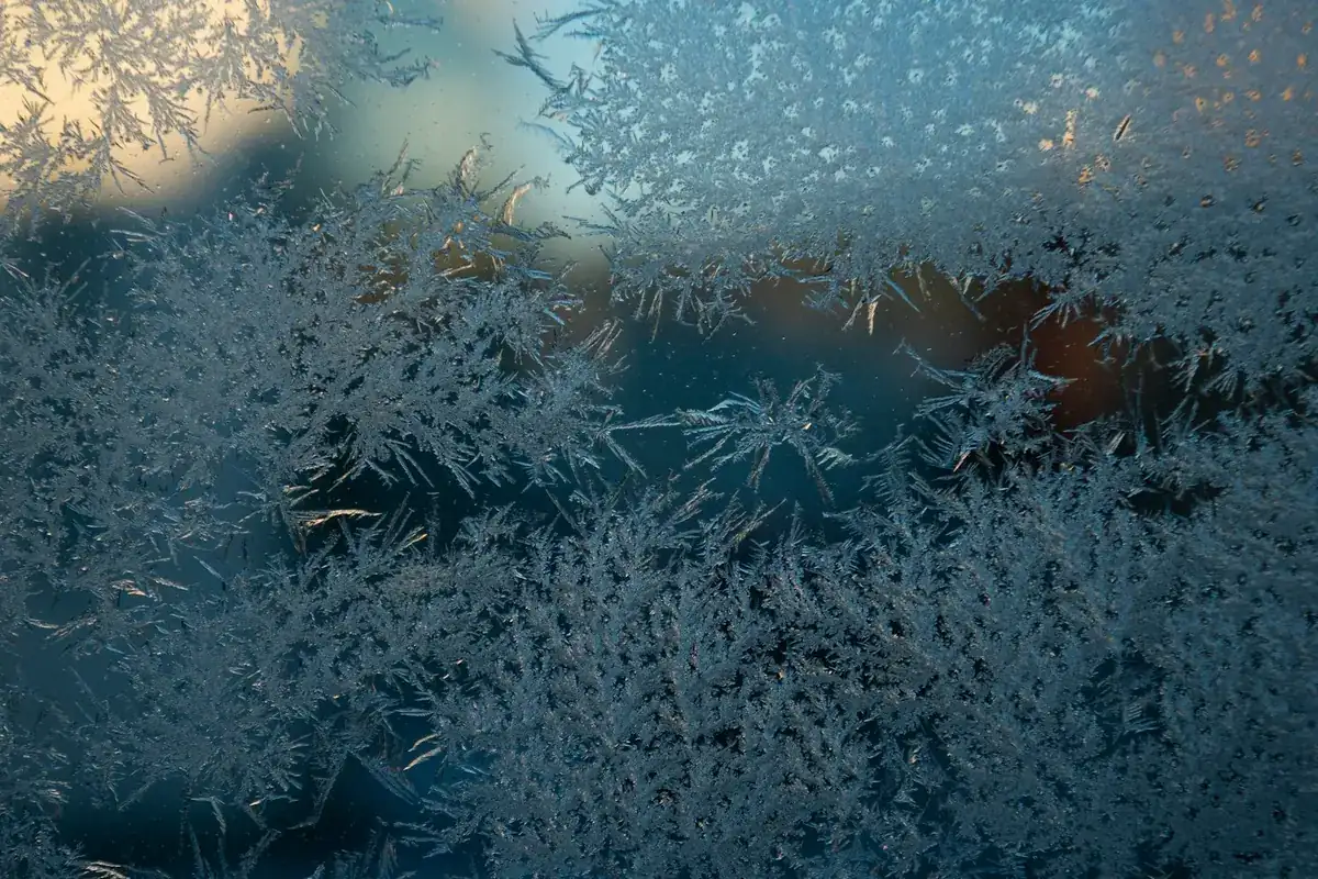 Water droplets and frost on a window pane in winter